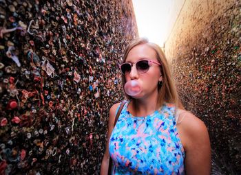 Portrait of young woman wearing sunglasses standing outdoors