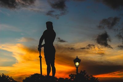 Low angle view of silhouette people against cloudy sky