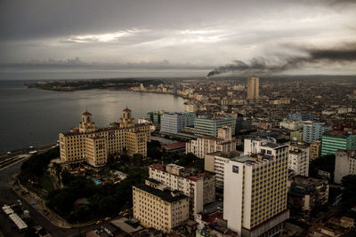 High angle view of buildings by sea against sky