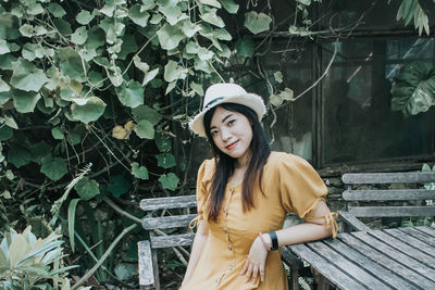 Beautiful young woman standing against plants