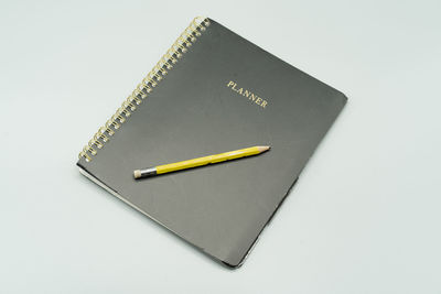 High angle view of pencil on book against white background