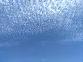 Full frame shot of snowflakes on blue sky