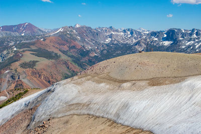 Snow melting at the top of mammoth mountain ca, revealing the colorful mountains in the background
