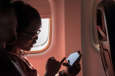 Panoramic view of woman using a mobile phone at the airplane