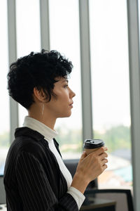 Side view of a woman holding coffee cup
