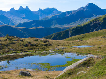 Scenic view of lake and mountains against blue sky