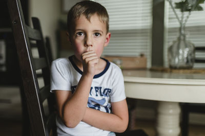 Young boy sucking thumb at the table in pajamas in buda texas