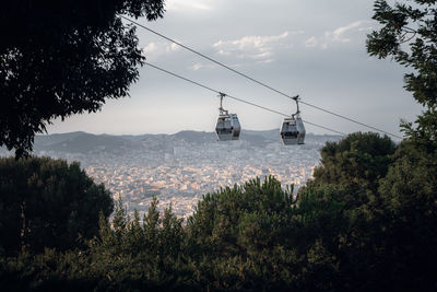 Overhead cable car over mountains against sky