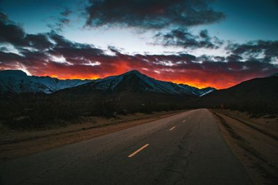 Road amidst mountains against sky during sunset