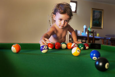 Girl playing with snooker balls on pool table