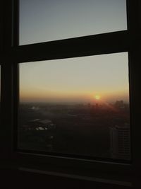 Cityscape against sky seen through glass window