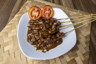 Sate ayam, satays with peanut sauce, famous indonesian cuisine potographed with high angle view