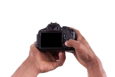 Close-up of hand holding camera over white background