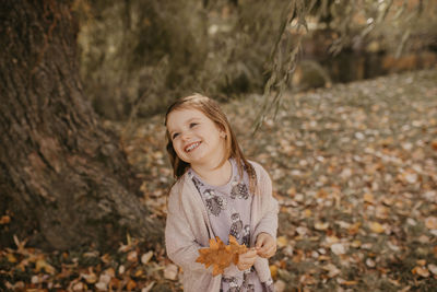 Portrait of a smiling young woman standing on land