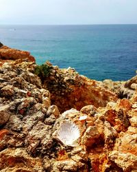 Close-up of rocks by sea against sky