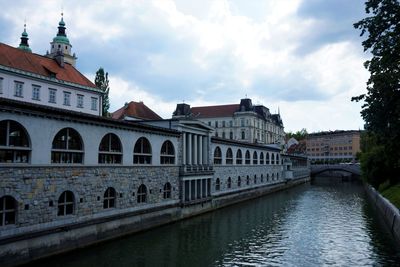 Bridge over river against buildings in city