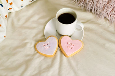 A cup of coffee with delicious cookies with the inscription love you.