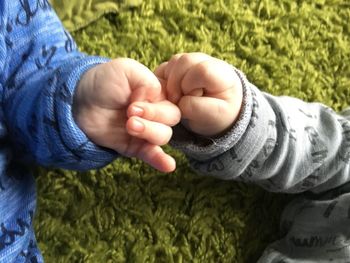 Low section of babies  holding hands twins 