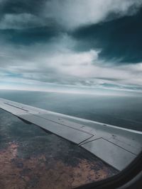 Airplane flying over sea against sky