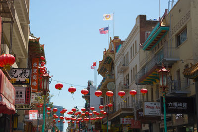 Lanterns hanging in city against sky