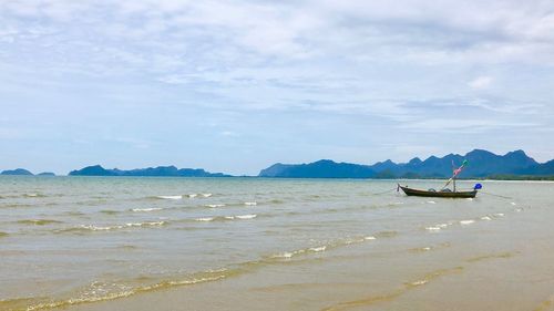 Scenic view of local fisherman boat in sea against sky 