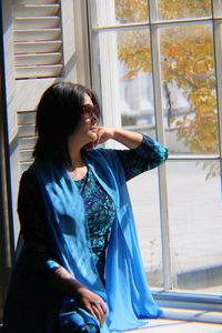Woman looking towards window while sitting at home