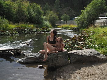 Side view of woman sitting on rock