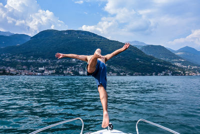 Shirtless man diving into lake