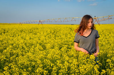 Young woman with yellow flowers in field