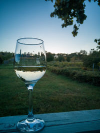 Close-up of wine glass on table against sky