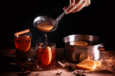 Close-up of drink with spices on table against black background