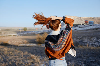 Rear view of woman standing at beach