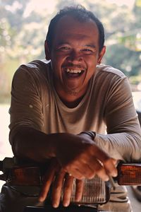 Portrait of cheerful man sitting on motor scooter