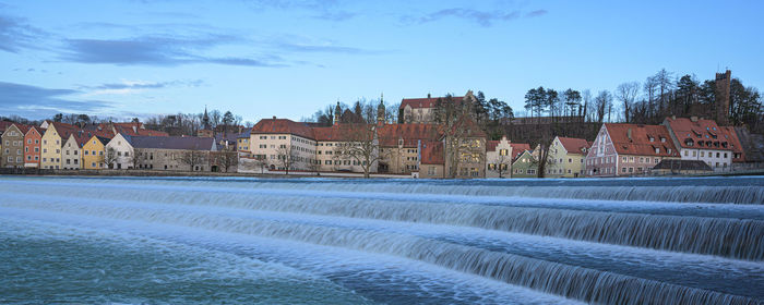 Panoramic shot of river by buildings against sky