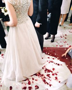 Low section view of newly wed couple with guests during wedding ceremony