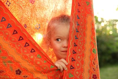 Cute girl playing hide and seek in lawn