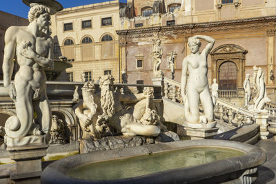 Statue of fountain in front of historical building