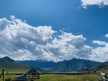 Scenic view of landscape and mountains against blue sky