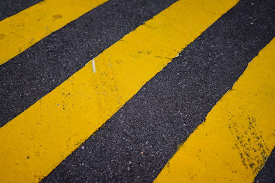 Close-up of yellow arrow symbol on road