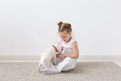 Cute girl playing with dog at home