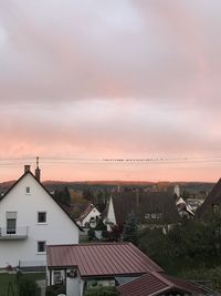 High angle view of buildings in town against sky during sunset