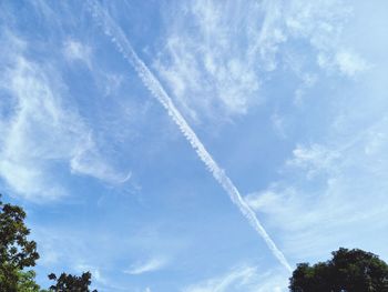 Low angle view of vapor trail against blue sky