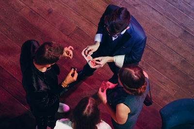 High angle view of magician showing tricks to people