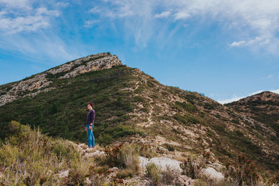 Man standing on mountain against sky