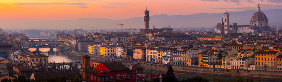 Aerial view of buildings in city at sunset