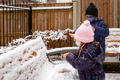 Rear view of boy and girl standing in snow