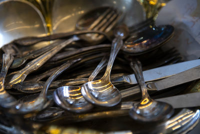 Close-up of steel spoons with forks and table knives