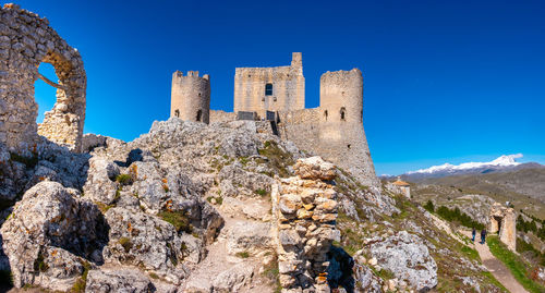 Low angle view of rock formations against clear blue sky