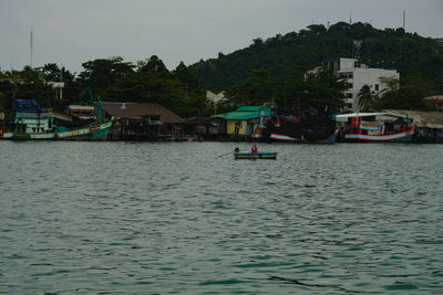 Houses by river against sky