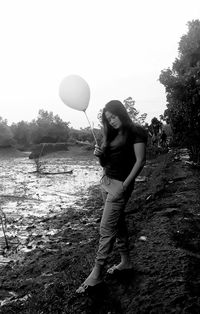 Full length of young woman standing on road